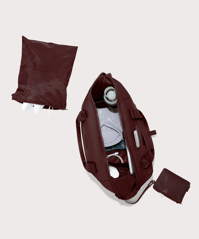 Dagne Dover Large Landon Carryall in a deep brown with purple undertones unzipped, top down view.