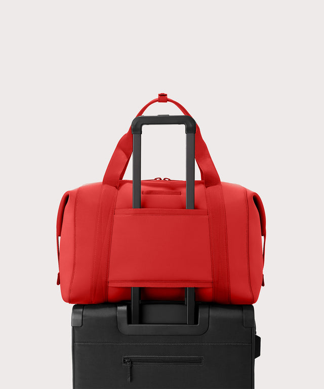 Dagne Dover Extra Large Landon Carryall in a fiery, saturated red leaning toward orange  displaying luggage sleeve.