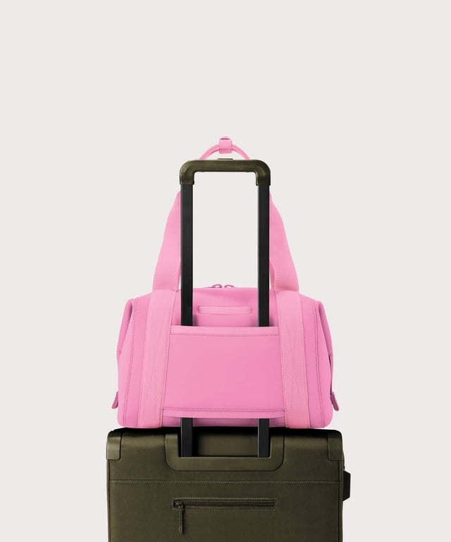 Dagne Dover Medium Landon Carryall in a true bubble gum pink on luggage, showing the luggage sleeve.