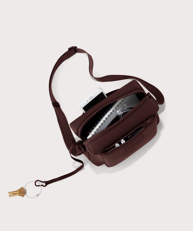Dagne Dover Micah Crossbody in a deep brown with purple undertones seen from above, showing the interior air mesh pocket.