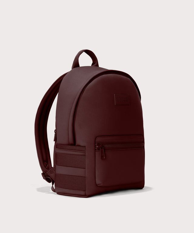 Dagne Dover Medium Dakota Neoprene Backpack in a deep brown with purple undertones seen from an angle.