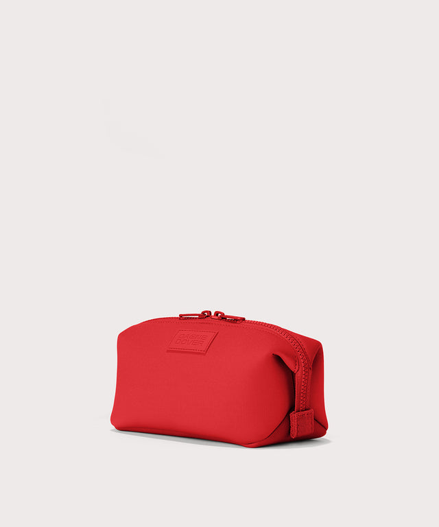 Dagne Dover Small Hunter Toiletry Bag in a fiery, saturated red leaning toward orange seen from an angle.