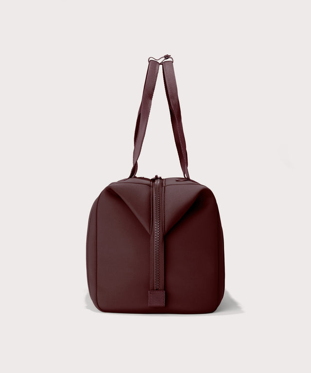 Dagne Dover Large Landon Carryall in a deep brown with purple undertones seen from the side.