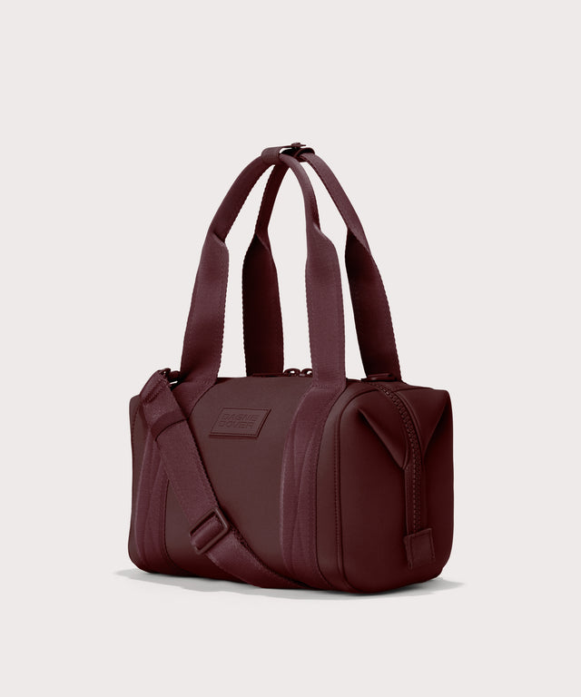 Dagne Dover Small Landon Carryall in a deep brown with purple undertones seen from an angle.