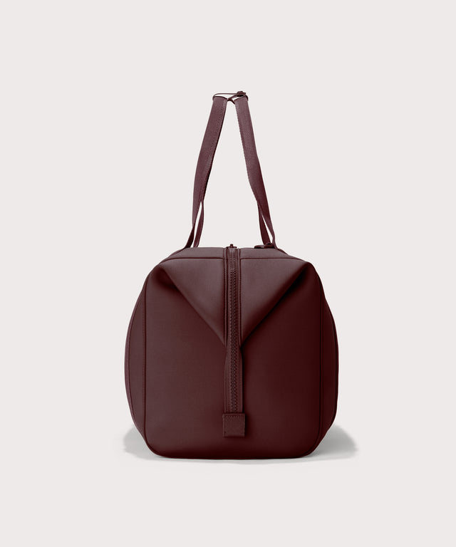 Dagne Dover Extra Large Landon Carryall in a deep brown with purple undertones seen from the side.