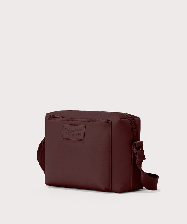 Dagne Dover Micah crossbody in a deep brown with purple undertones seen from an angle.