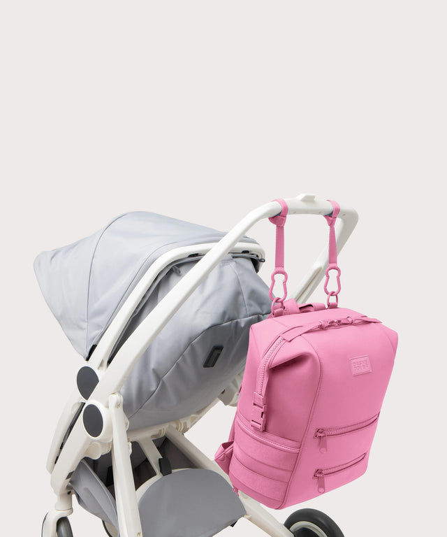 Dagne Dover Large Indi Diaper Backpack in a true bubble gum pink attached to a stroller.