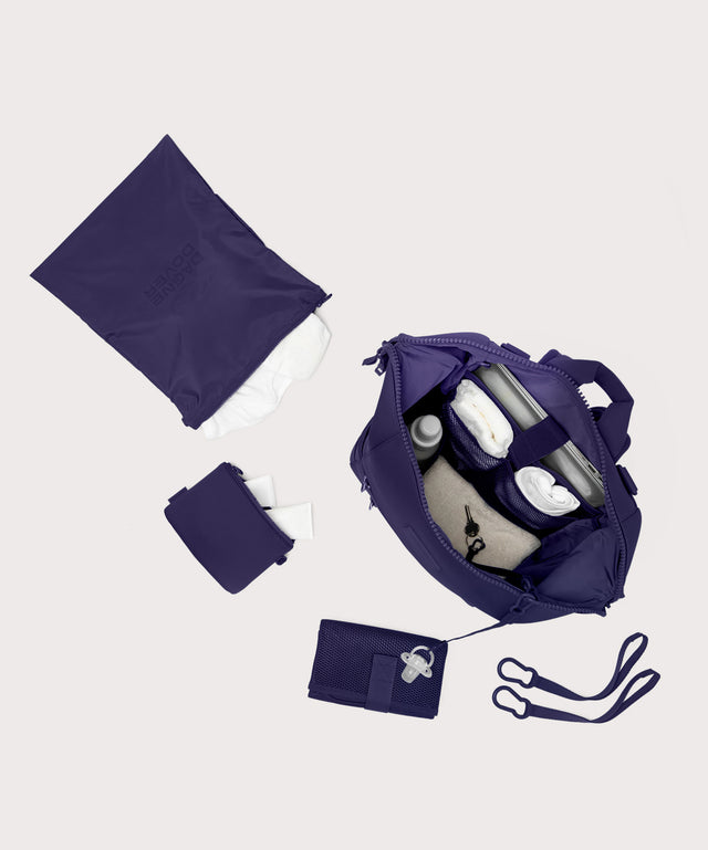 Large Indi backpack in a jewel-toned, deep blue with strong purple undertones. unzipped, top down view. 
