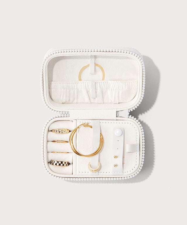 Dagne Dover small Frankie Jewelry Case in white, seen open from above with jewelry inside the interior compartment.