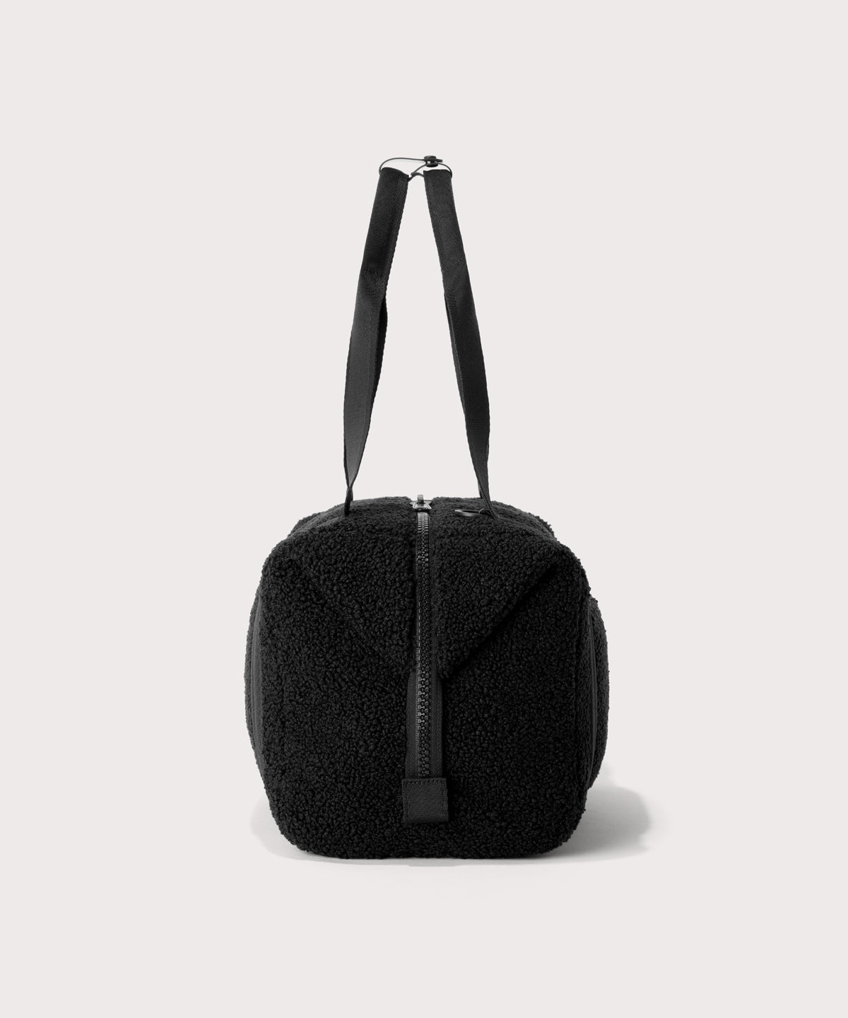 Medium landon carryall in a black., side view  In a  Faux Shearling  a soft, wool-like plush made with recycled materials
