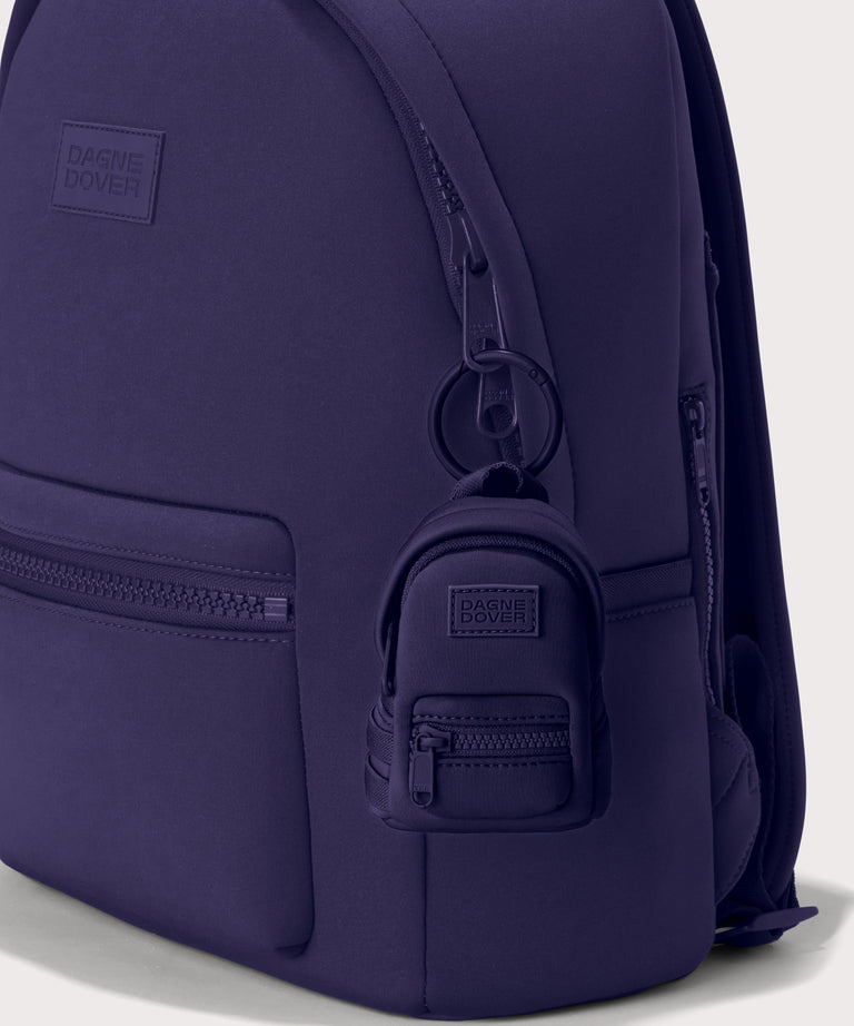Dakota keychain in a a jewel-toned, deep blue with strong purple undertones. front angle shown on a dakota backpack. 
