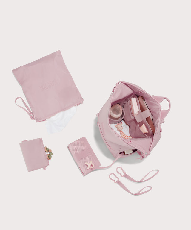 Large Indi backpack in a cool, powdery pink with soft grey undertones. unzipped, top down view. 
