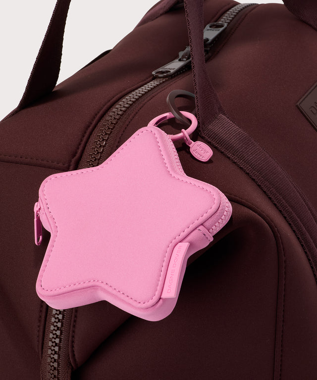 Dagne Dover Star Keychain in a true bubble gum pink seen clipped onto a bag.