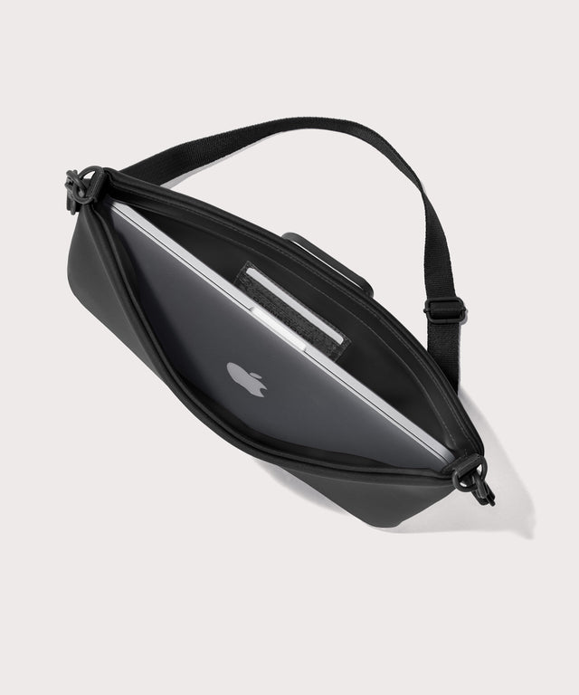14 inch laptop shoulder bag in a black seen from the top down view showing interior.
