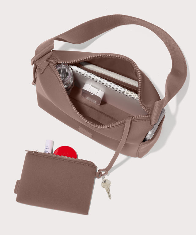 Shoulder bag in a pink seen from the top down view showing interior mesh pouch.
