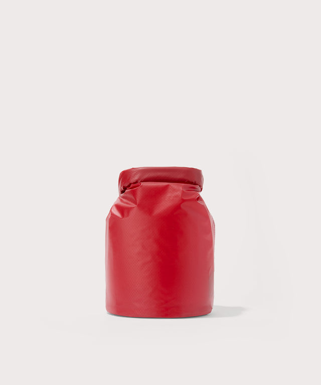 Dagne Dover Rae Roll-Top Dry Bag in a fiery, saturated red leaning toward orange seen from the back.