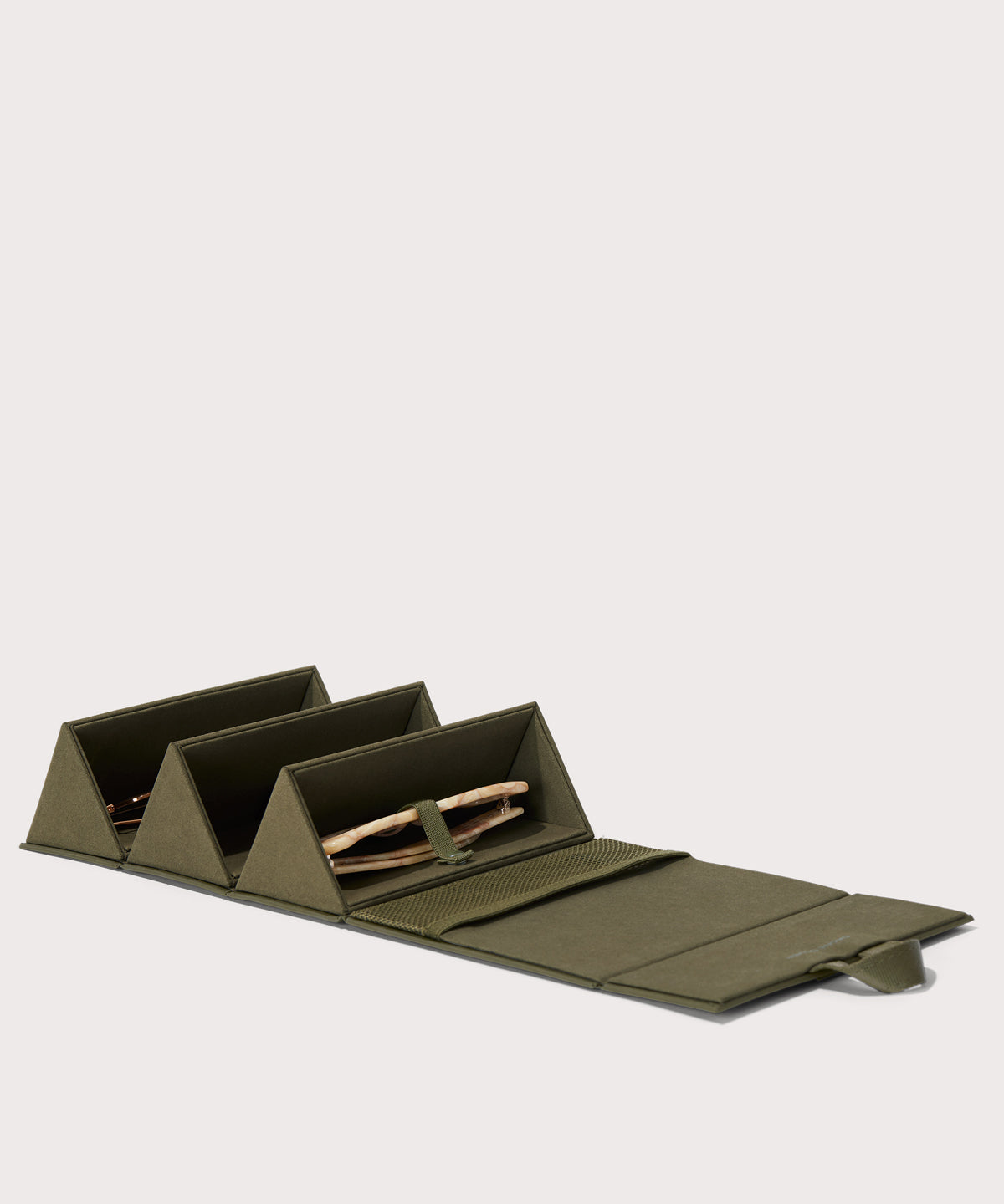 Dagne Dover Remi foldable glasses holder in dark green, unfolded and containing sunglasses.
