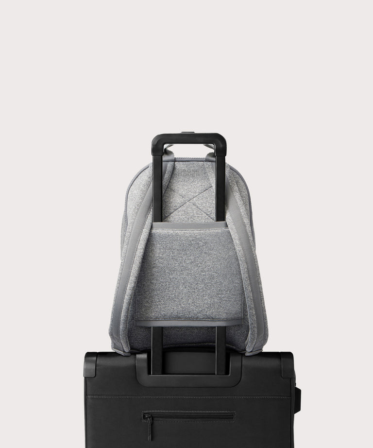 Dagne Dover large Dakota Neoprene Backpack in grey strapped to luggage with the neoprene luggage-handle sleeve.
