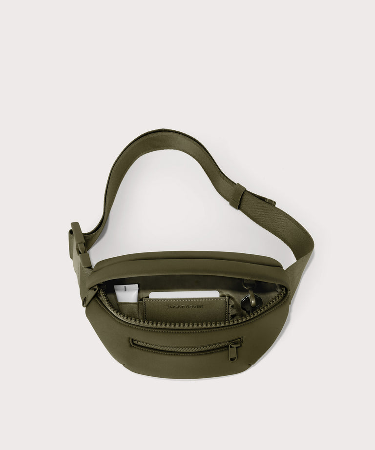 Dagne Dover Ace Fanny Pack in  dark green  unzipped, exposing the interior pockets
