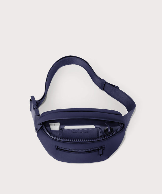 Dagne Dover Ace Fanny Pack in  dark blue  unzipped, exposing the interior pockets

