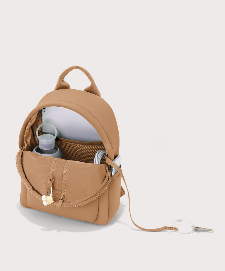Dagne Dover Dakota Small Neoprene Backpack in camel unzipped, revealing the interior air mesh pockets.