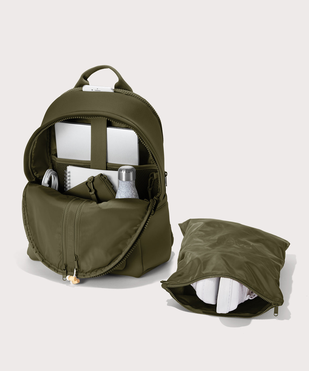 Dagne Dover large Dakota Neoprene Backpack in dark moss unzipped, showing the interior pockets and shoe bag.