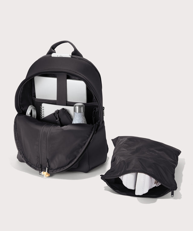 Dagne Dover large Dakota Neoprene Backpack in black unzipped, showing the interior pockets and shoe bag.
