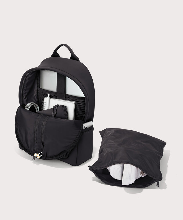 Dagne Dover medium Dakota Neoprene Backpack in onyx unzipped, showing the interior pockets and shoe bag.