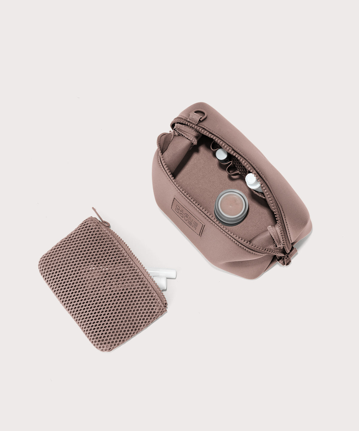 Dagne Dover Small Hunter Toiletry Bag in pink unzipped and seen from above with the removable air mesh pouch alongside it.