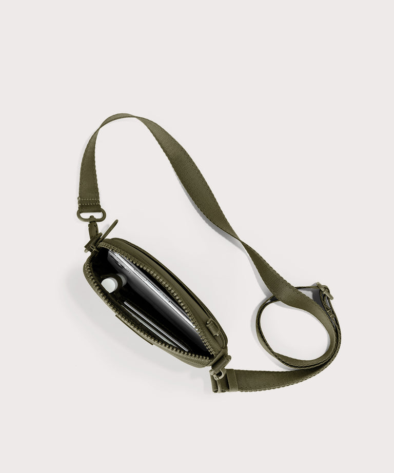 Dagne Dover Mara Phone Sling unzipped in dark green seen from above, exposing the interior card slots.