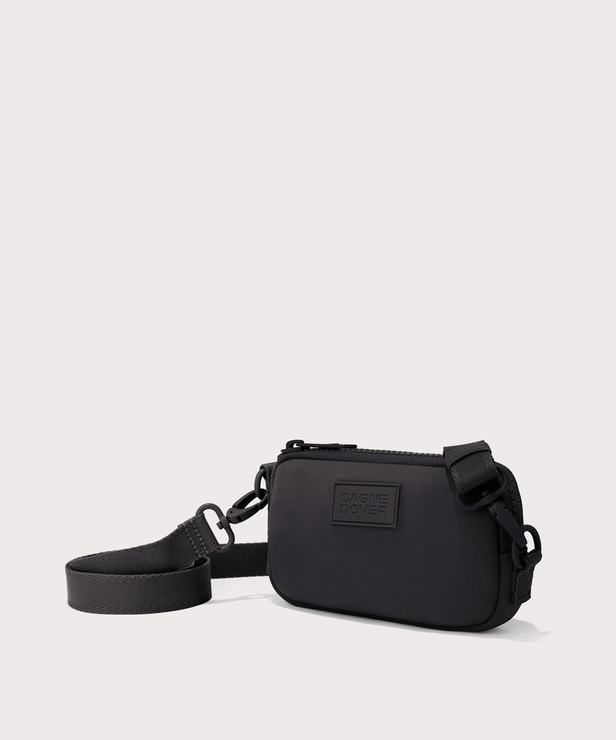 Dagne Dover Mara Phone Sling in black seen from an angle, showing the adjustable shoulder strap drop.
