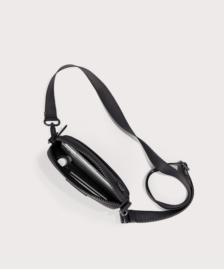 Dagne Dover Mara Phone Sling unzipped in black seen from above, exposing the interior card slots.