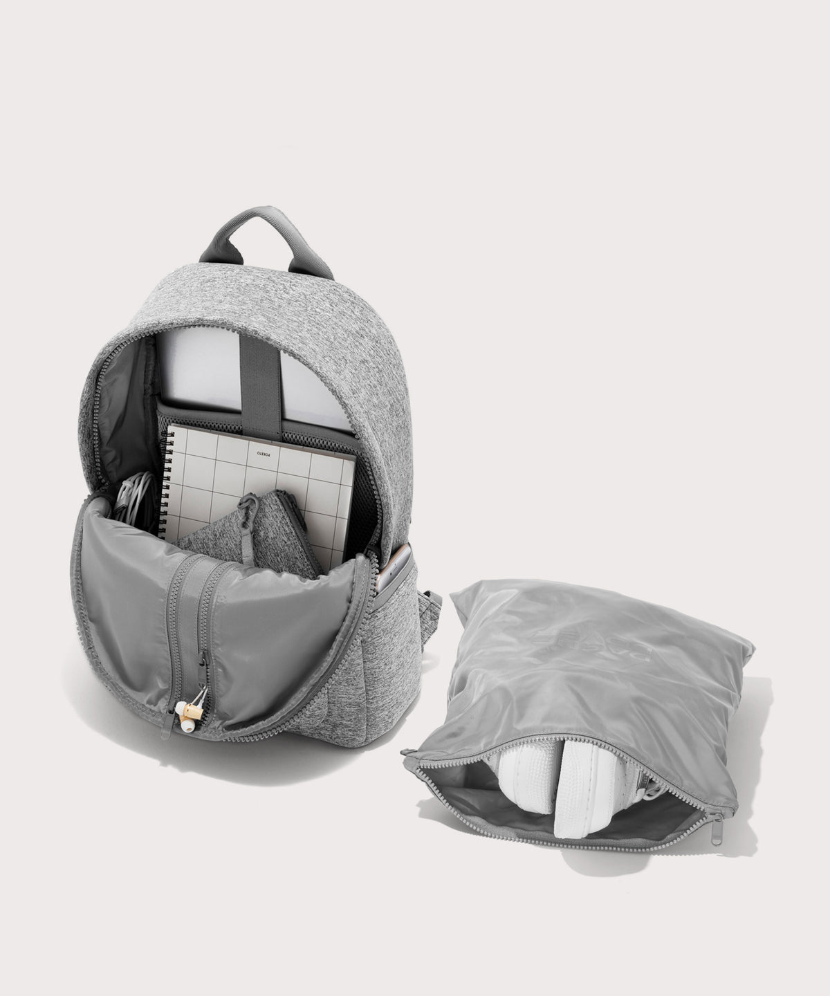 Dagne Dover medium Dakota Neoprene Backpack in grey unzipped, showing the interior pockets and shoe bag.
