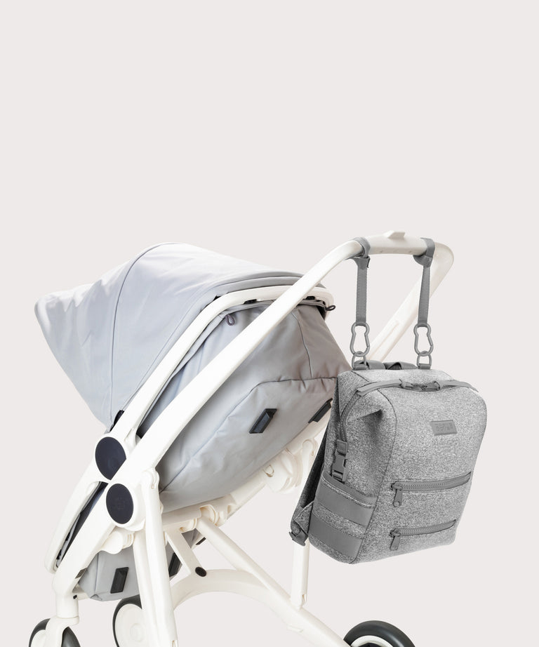 Dagne Dover medium Indi Diaper Backpack in grey attached to a stroller.

