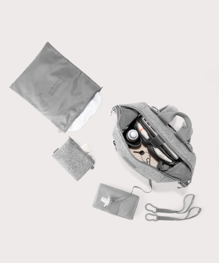 Dagne Dover medium Indi Diaper Backpack in grey showing it's water resistant bag, interior pockets, and changing mat.