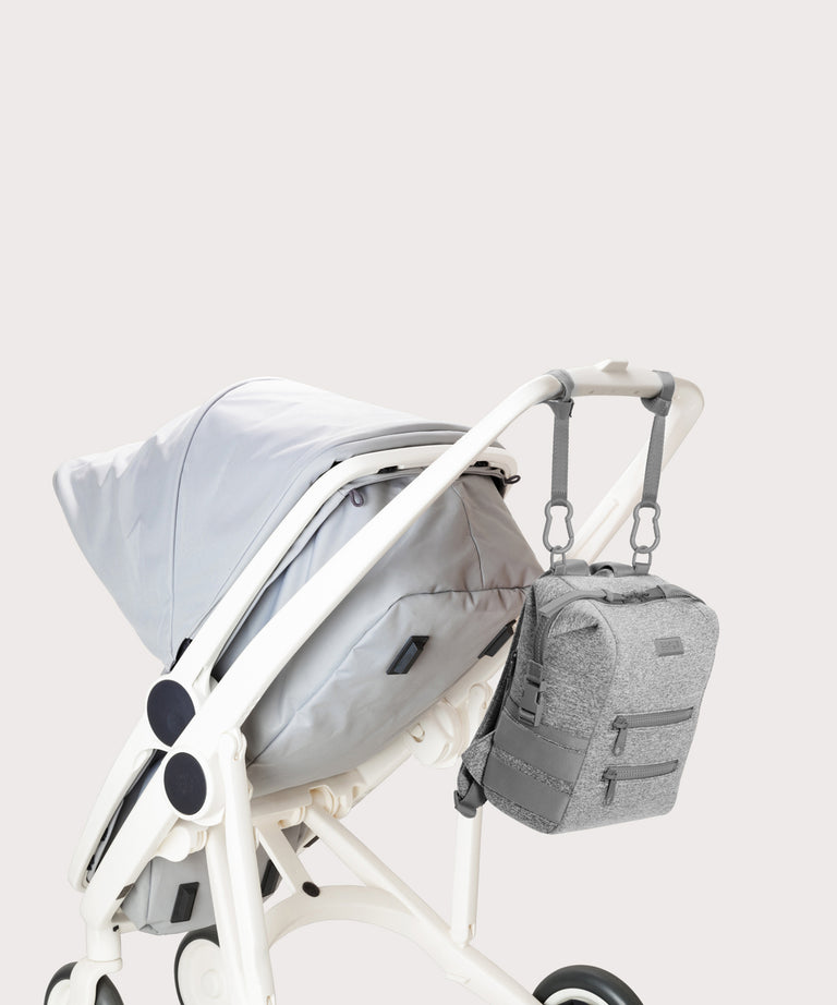 Dagne Dover small Indi Diaper Backpack in grey attached to a stroller.
