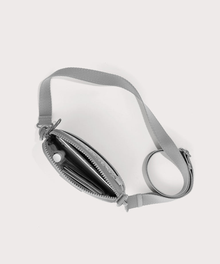 Dagne Dover Mara Phone Sling unzipped in grey seen from above, exposing the interior card slots.