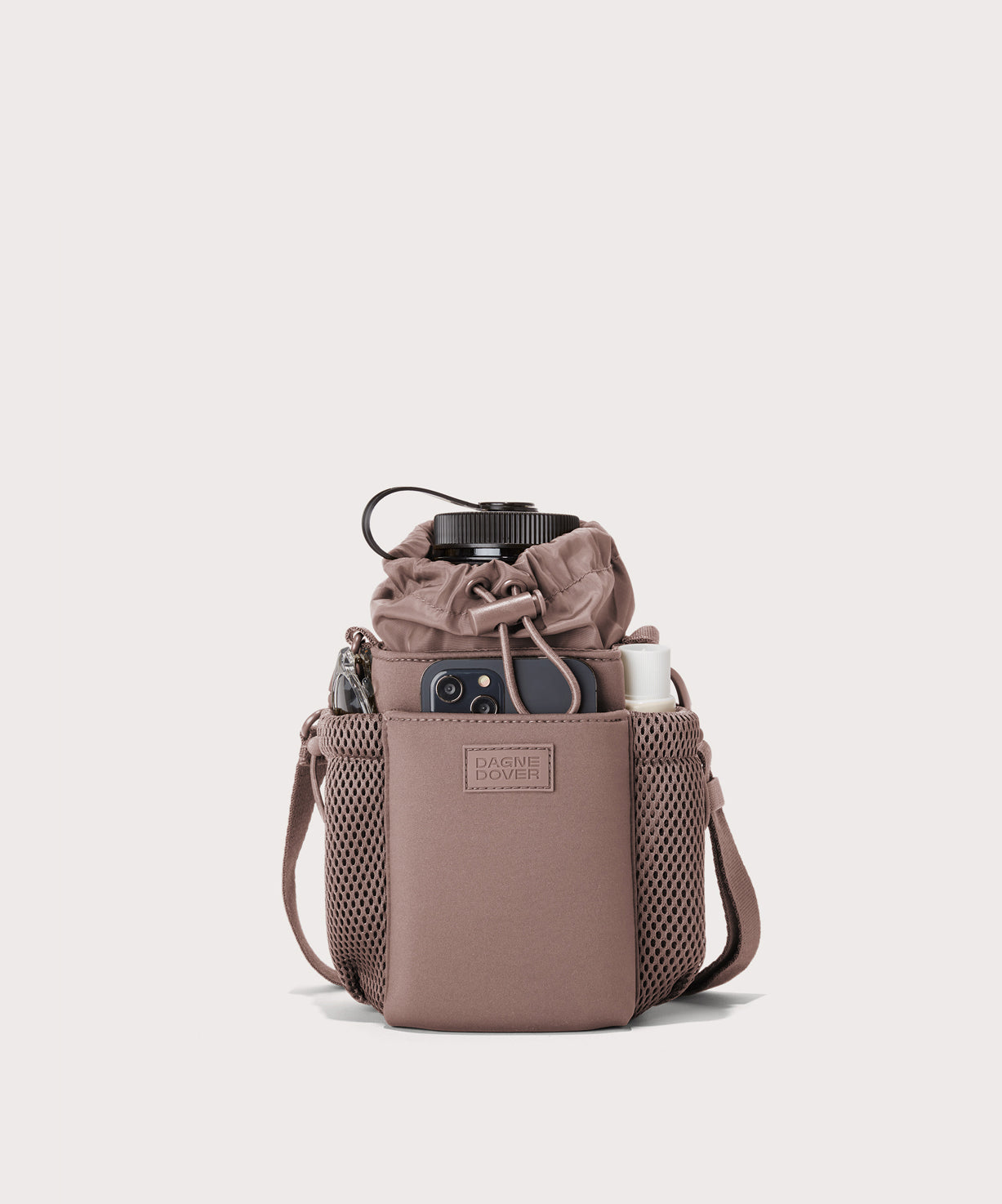 Dagne Dover Sloan Water Bottle Sling in pink containing a water bottle and accessories.