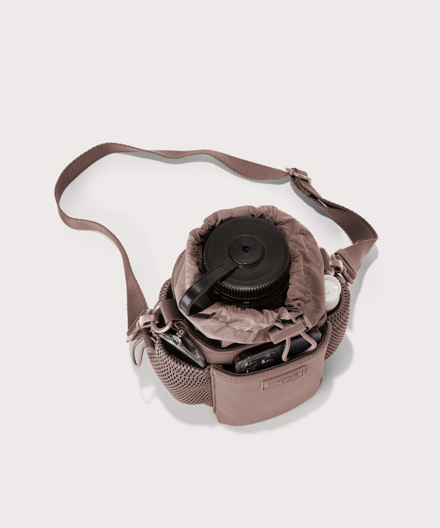 Dagne Dover Sloan Water Bottle Sling in pink seen from above containing a water bottle and accessories 