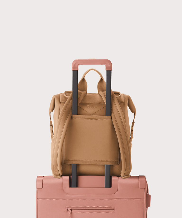 Dagne Dover Medium Indi Diaper Backpack in camel brown showing the neoprene luggage sleeve.
