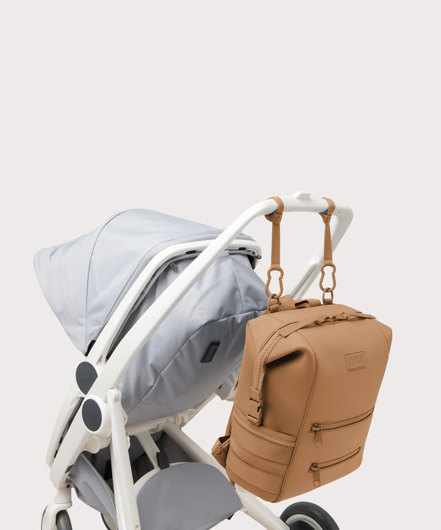 Dagne Dover Large Indi Diaper Backpack in camel brown attached to a stroller.
