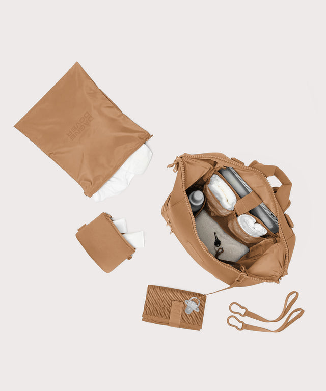 Dagne Dover Large Indi Diaper Backpack in camel brown showing it's water resistant bag, interior pockets, and changing mat.
