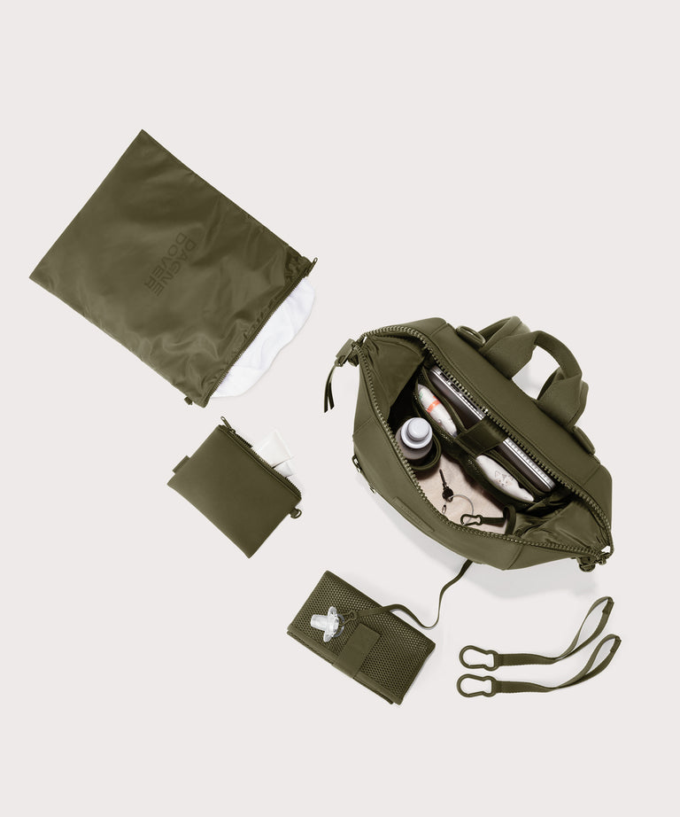 Dagne Dover medium Indi Diaper Backpack in dark moss showing it's water resistant bag, interior pockets, and changing mat.