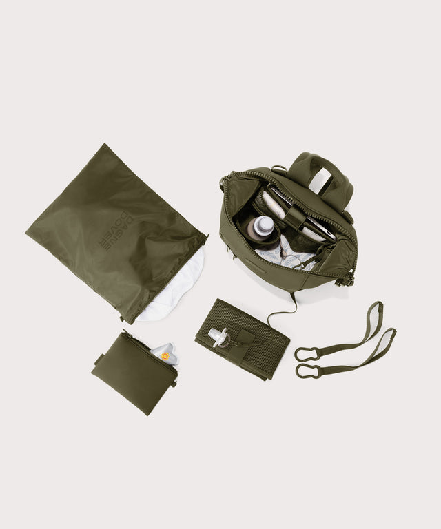 Dagne Dover small Indi Diaper Backpack in dark moss showing it's water resistant bag, interior pockets, and changing mat.