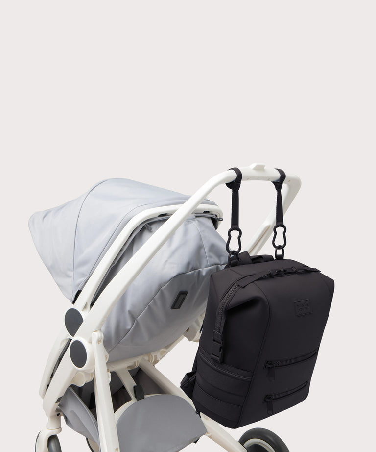 Dagne Dover Large Indi Diaper Backpack in onyx attached to a stroller.
