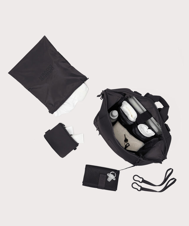 Dagne Dover Large Indi Diaper Backpack in onyx showing it's water resistant bag, interior pockets, and changing mat.