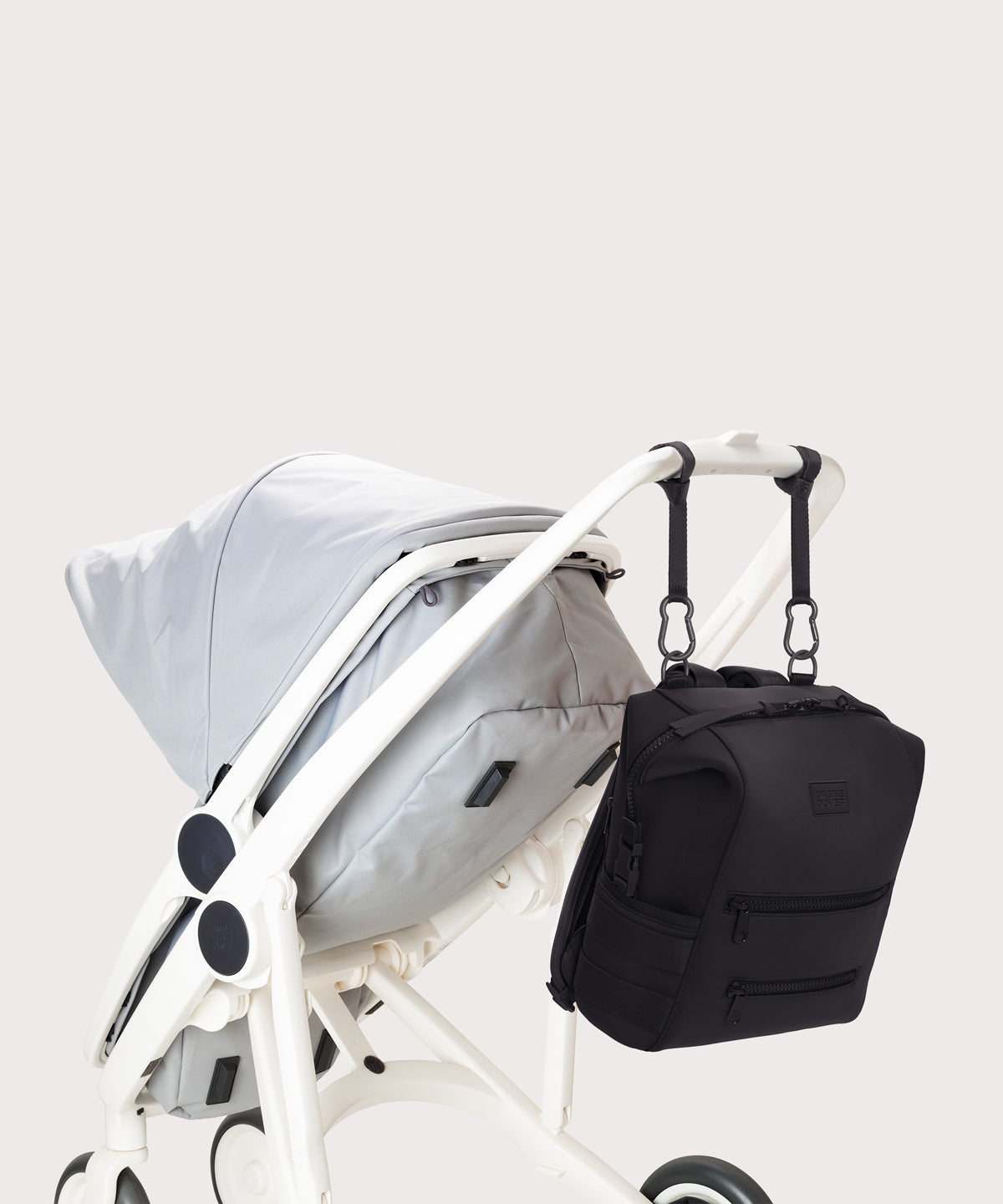 Dagne Dover medium Indi Diaper Backpack in black attached to a stroller.
