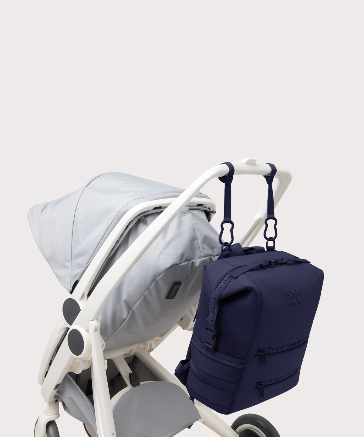 Dagne Dover Large Indi Diaper Backpack in dark blue attached to a stroller.
