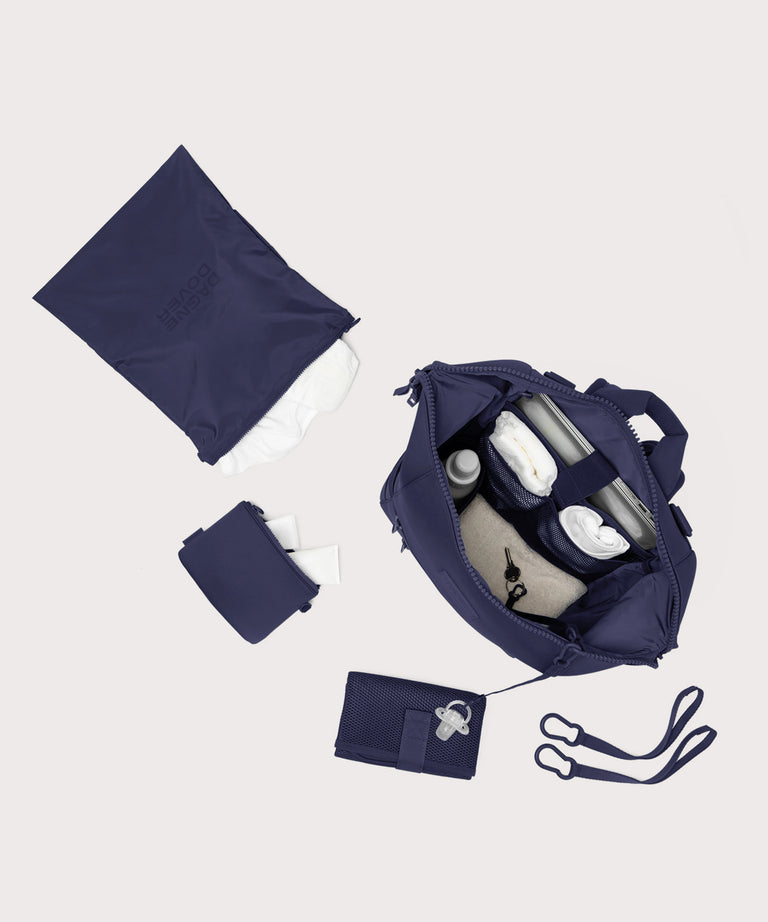 Dagne Dover Large Indi Diaper Backpack in dark blue showing it's water resistant bag, interior pockets, and changing mat.