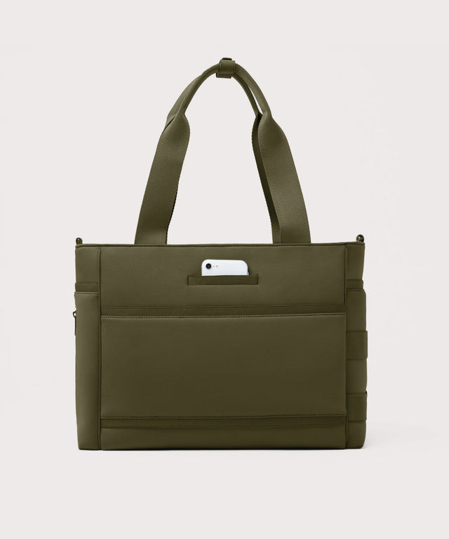 Dagne Dover large Wade Diaper Tote in dark green seen from the back with a phone in the exterior phone pocket.
